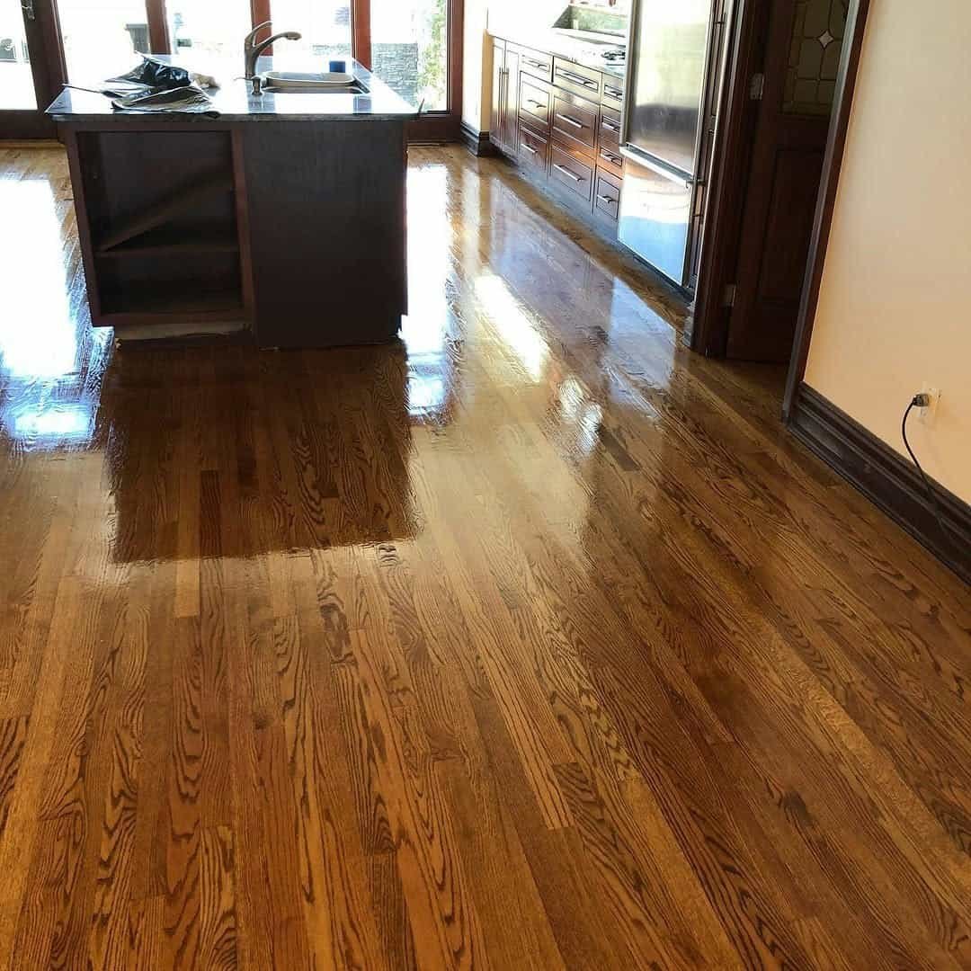 Freshly sanded oak planks during a professional hardwood flooring installation in a bright NYC apartment.