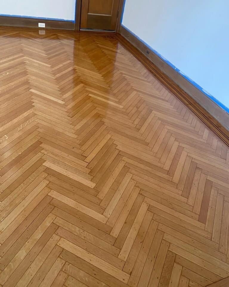 Newly installed herringbone wood floor in a Park Slope home featuring a high-gloss polyurethane finish.