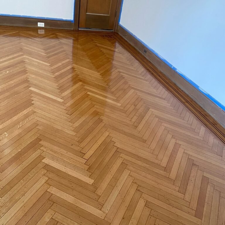 Newly installed herringbone wood floor in a Park Slope home featuring a high-gloss polyurethane finish.