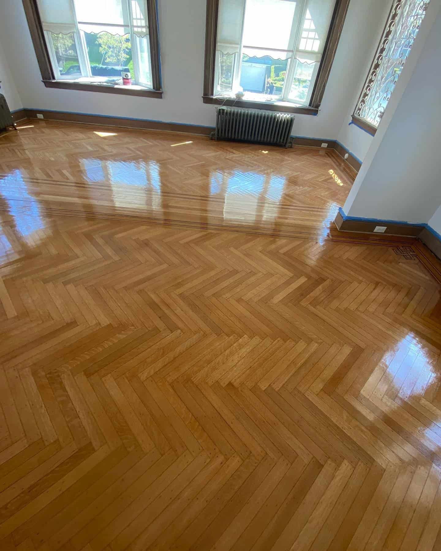 Close up of a natural wood herringbone pattern showing detailed grain and professional refinishing work.