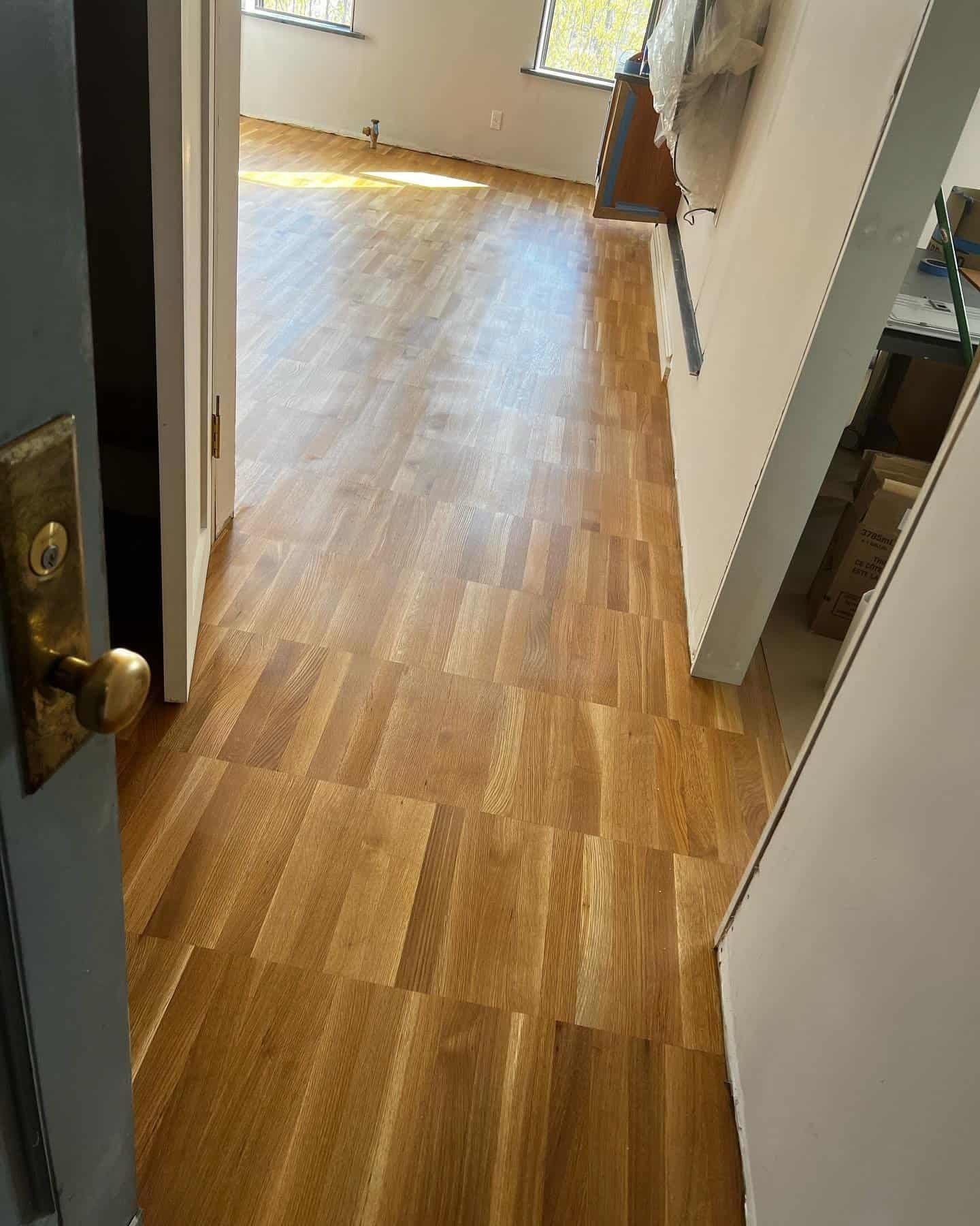 Wide view of custom hardwood flooring installation showing high quality wood grain in a local NYC living space.
